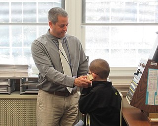 Neighbors | Jessica Harker.Poland Union Principal Mike Masucci helped second grade student Aiden McDonald, who was selected as principal for the day, call students to the office over the loud speaker.