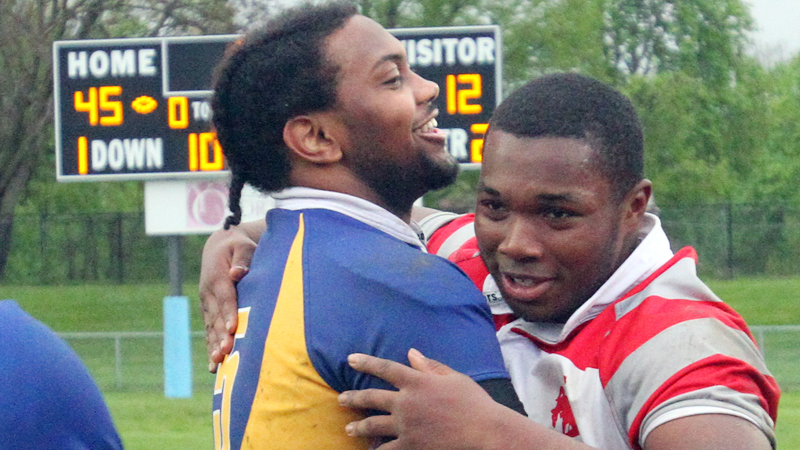 East's Turhan Henderson (5) and Chaney's Terrance Love hug after East defeated Chaney 45-12 at Rayen Stadium on Friday night.