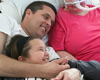 William D. Lewis The Vindicator  Christine Terlesky , who has ALS, shares a moment with her husband Brian in their Boardman home 4-4-19. Daughter Emma is at left.