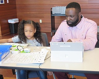 Neighbors | Jessica Harker .Ava Wise and her father Lorenzo Wise II worked on constructing a robot at the Michael Kusalaba library's Lego WeDo Robots event April 19.