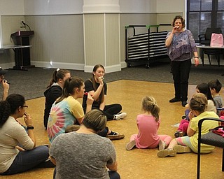 Neighbors | Abby Slanker.Canfield High School senior and National Honor Society member Isabella Audia (center) led children in playing the kazoo during the Spring Sing at the Canfield library on April 13.
