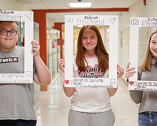 Colin Mateo, 13, left, Faith Stellato, 14, and Brooke Adams, 14, all Struthers eighth-graders, hold photo frames during a career event at the middle school showing what path they would choose. 
