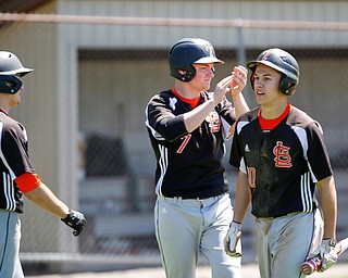 From left, Springfield's Clayton Nezbeth, Brannon Brungard, and Mitch Seymour celebrate after Brungard and Seymour score during the seventh inning of their game against South Range on Saturday at Springfield High School. Springfield won in the 10th inning 9-8. EMILY MATTHEWS | THE VINDICATOR