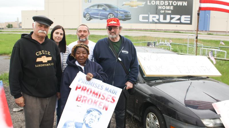 From left. Werner Lange of Newton Falls, Cheryl Jonesco of Lake Milton, Hattie Wilkins of Youngstown. Chuckie Denison of Lake Milton and Sean O’Toole of Youngstown stand near signs in front of the Chevrolet Cruze picture on the outside of the GM Lordstown complex, where they spoke against the tentative sale of the complex to Cincinnati’s Workhorse Group.
