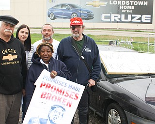 From left. Werner Lange of Newton Falls, Cheryl Jonesco of Lake Milton, Hattie Wilkins of Youngstown. Chuckie Denison of Lake Milton and Sean O’Toole of Youngstown stand near signs in front of the Chevrolet Cruze picture on the outside of the GM Lordstown complex, where they spoke against the tentative sale of the complex to Cincinnati’s Workhorse Group.