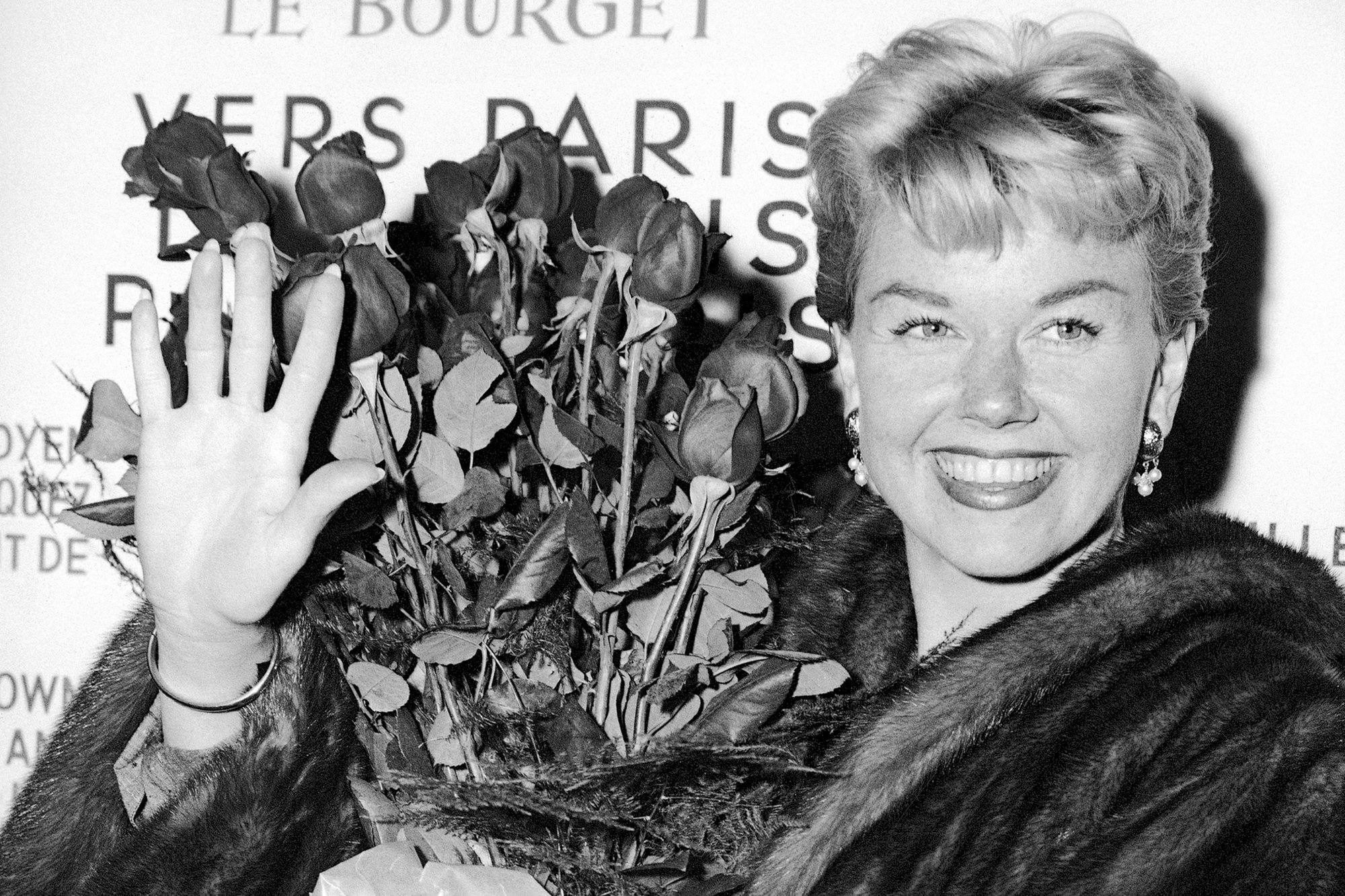 In this April 15, 1955, file photo, American actress and singer Doris Day holds a bouquet of roses at Le Bourget Airport in Paris after flying in from London. The Doris Day Animal Foundation confirmed Day died early Monday, May 13, 2019, at her home in Carmel Valley, Calif. She was 97.  