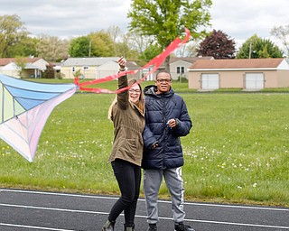 Hailey Black, left, a student teacher in Angela Dooley's 10th grade English class, helps Sedric Woods, 15, a ninth grader at Chaney High School, fly a kite during a fundraiser for Save the Children, an organization that helps child refugees, on the track at Chaney High School on Tuesday afternoon. EMILY MATTHEWS | THE VINDICATOR