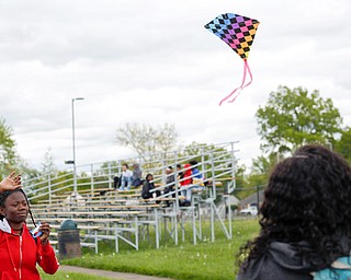 Alaja Johnson, left, 17, an 11th grader at Chaney High School, flies a kite while Nakaia McRae, 16, an 11th grader, watches during a fundraiser for Save the Children, an organization that helps child refugees. The event was on the track at Chaney on Tuesday afternoon. 
