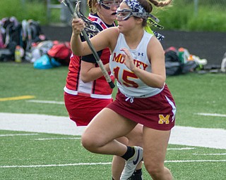 Mia Stana of Cardinal Mooney does her best to escape a Canfield defender in a Division II tournament game at Don Bucci Field on Thursday.