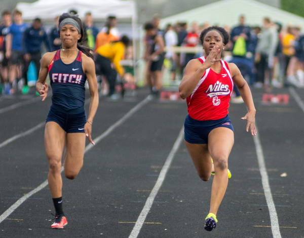 Chante Clinkscale of Niles McKinley (right) outduels Alena Williams of Austintown Fitch in the 100-meter dash in the Division I District Track and Field Meet at Greenwood Chevrolet Falcon Stadium on Friday night.