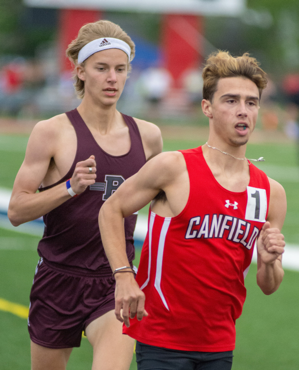 Giovanni Copploe of Canfield moves ahead of Mitchel Dunham of Boardman in the 1,600-meter run in the Division I District Track and Field Meet at Greenwood Chevrolet Falcon Stadium on Friday night..