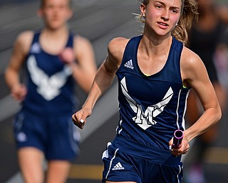 NEW SPRINGFIELD, OHIO - MAY 17, 2019: McDonald's Bella Wolford takes off after receiving the baton during the girls 4x200 meter relay, Friday night during the Division III District Track Meet at Springfield High School. DAVID DERMER | THE VINDICATOR