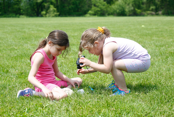 Sisters Mia Niznik, 6, left, and Maylee Niznik, 4, both of Struthers, look for flowers and bugs at Kids to Parks Day at Ipe Field on Saturday afternoon. EMILY MATTHEWS | THE VINDICATOR