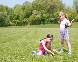 Sisters Mia Niznik, 6, left, and Maylee Niznik, 4, both of Struthers, look for flowers and bugs at Kids to Parks Day at Ipe Field on Saturday afternoon. EMILY MATTHEWS | THE VINDICATOR