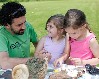 Josh Boyle, left, of Boardman and with Environmental Collaborative of Ohio, looks at flowers found by sisters Maylee Niznik, 4, center, and Mia Niznik, 6, both of Struthers, at Kids to Parks Day at Ipe Field on Saturday afternoon. EMILY MATTHEWS | THE VINDICATOR