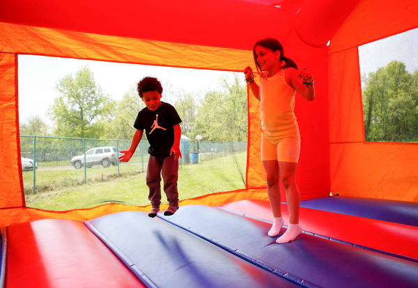 Noah Axel, 3, of Poland, left, and Mya Niznik, 6, of Struthers, play in a bounce house at Kids to Parks Day at Ipe Field on Saturday afternoon. EMILY MATTHEWS | THE VINDICATOR