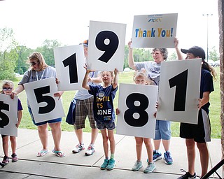 From left, Madison Himes, 6, who has cystic fibrosis, Maggie Himes, John Himes, Aislynn Himes, 8, all of New Middletown, Tessa Carrabbia, 8, of Austintown, Claudia Mehocic, of Pulaski, and Melina Carrabbia, 11, of Austintown, hold up signs that read $51,981, which is how much money was raised during the 20th annual Mahoning/Trumbull Great Strides cystic fibrosis walk at Boardman Park on Sunday afternoon. EMILY MATTHEWS | THE VINDICATOR