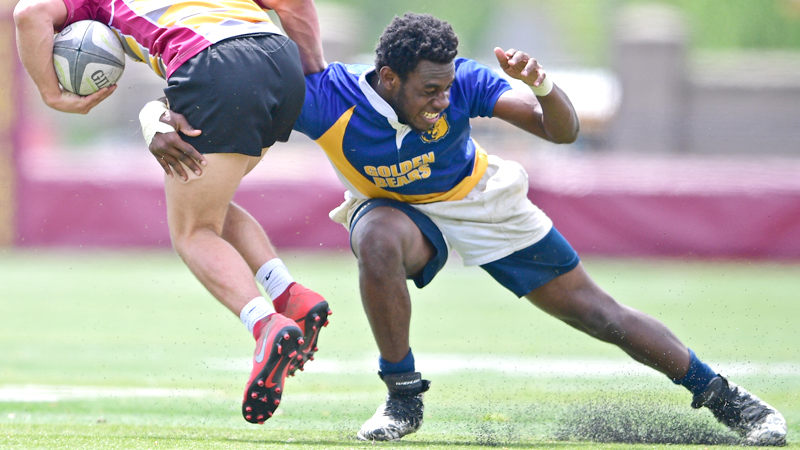 East’s Rayshon Pearce carries the ball as an Avon Lake 
defender tries to bring him down during a Division II rugby tournament match Sunday at Avon Lake High School. 
The Shoremen beat the Golden Bears, 43-7.
