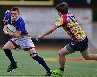 AVON LAKE, OHIO - MAY 19, 2019: Youngstown East's Samuel Cartagena runs with he ball away from a Avon Lake defender during the first half of their game, Sunday afternoon at Avon Lake High School. DAVID DERMER | THE VINDICATOR
