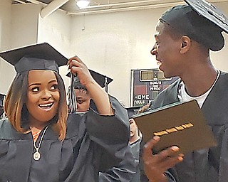 Mahoning County High School graduates Nathaniel Austin, right, and Craigranza Bembry share a glance after ceremoniously turning the tassels on their graduation caps during the school’s commencement ceremony Tuesday morning.