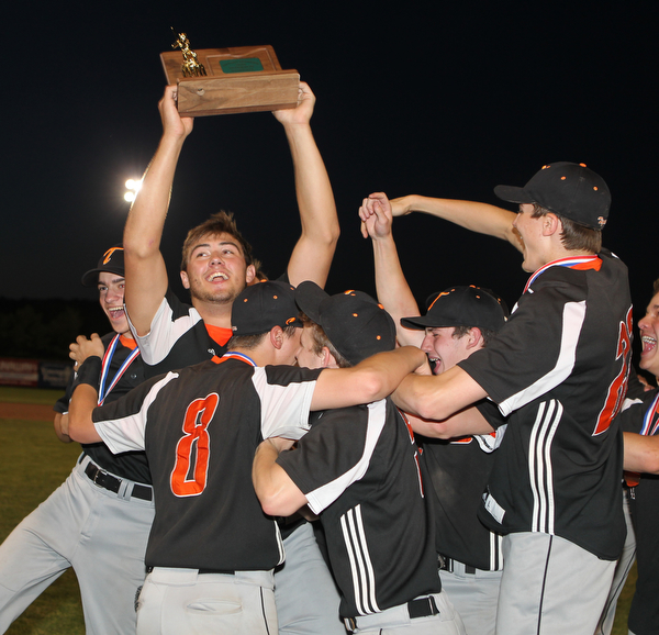 Shane Eynon of Springfield is surrounded by his teammatres as he holds up the District Champion trophy after he had a one out walk off single in the bottom of the seventh inning to defeat Warren JFK at Cene Park in Struthers on Thursday night.   Dustin Livesay  |  The Vindicator  5/23/19  Cene Park.