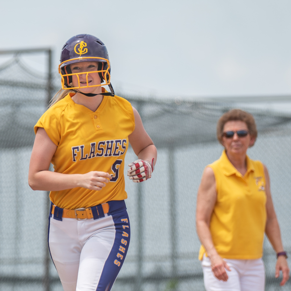 DIANNA OATRIDGE | THE VINDICATOR  Champion's Cassidy Shaffer smiles as she heads home past Coach Cheryl Weaver after hitting a solo home run during their Division III Regional Final game versus Northwestern on Saturday in Massillon. Champion won 3-0.