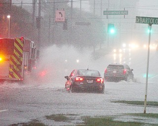 Motorists and a fire truck make their way in a downpour and through deep water along Market Street in Boardman Township on Tuesday night near the Southwoods medical complex.