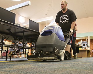 Tom Timlin runs a water vacuum in the computer room at Canfield Middle School. Canfield schools were closed Wednesday because of damage caused by Tuesday night's flooding. Schools were set to reopen today.