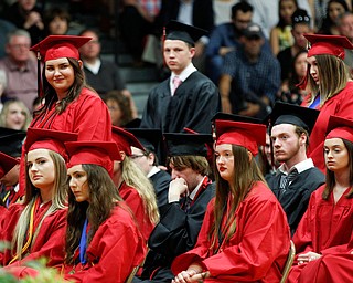 From left, Canfield seniors, Megan Burkett, Paris Bumgardner, and Sophia Campos stand in recognition of receiving financial aid for college during the Canfield High School commencement ceremony in Canfield High School on Friday evening. EMILY MATTHEWS | THE VINDICATOR
