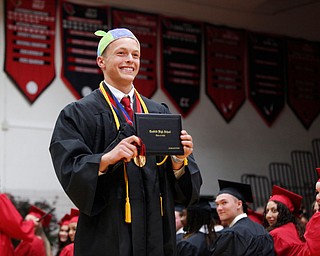 Jacob Pitzer wears a propeller hat as he holds his diploma during the Canfield High School commencement ceremony in Canfield High School on Friday evening. EMILY MATTHEWS | THE VINDICATOR