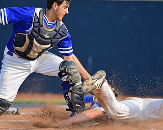 Gilmour Academy's Nick Christopher tags out Alex Barth of Poland Seminary High School at home plate in the fourth inning of Friday night's Division II Regional semifinal game at Hudson High School. Gilmour Academy won 11-0. 