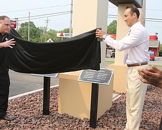 Ralph Delserone, left, owner of the Niles Park Plaza, and Niles Mayor Steve Mientkiewicz remove the covering on the plaques dedicated to those that died when a tornado struck the city May 31, 1985, and the names of the Niles residents killed in the storm.