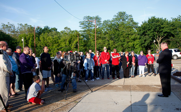 Michael Cline, right, the outreach director at Apostolic Pentecostal Church in Warren, speaks to a group gathered for a vigil to honor Brad and Jacob Crist, who died in a house fire in Niles last week, at the Niles Safety-Service Complex on Sunday evening. EMILY MATTHEWS | THE VINDICATOR