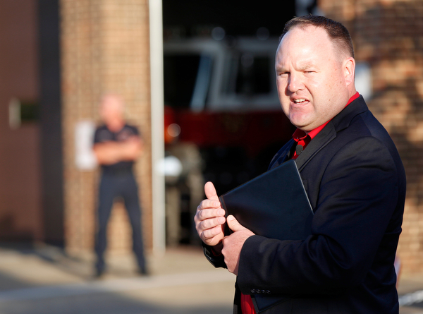 Michael Cline, right, the outreach director at Apostolic Pentecostal Church in Warren, speaks during a vigil for Brad and Jacob Crist, who died in a house fire in Niles last week, at the Niles Safety-Service Complex on Sunday evening. EMILY MATTHEWS | THE VINDICATOR