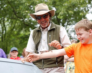 Jungle Terry Sullivan, left, guides a tree frog off the arm of Alexander Krok, 8, of Boardman, at Riverfest on Sunday afternoon. EMILY MATTHEWS | THE VINDICATOR