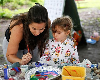 Luccia Cycyk, 2, right, paints on rocks with her aunt Carly Giancola, both of Canfield, at Riverfest on Sunday afternoon. EMILY MATTHEWS | THE VINDICATOR