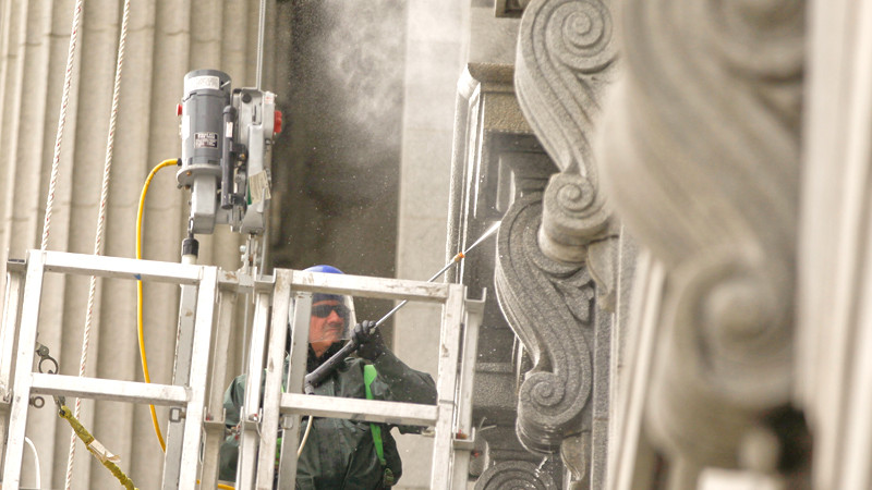 Workers wash the side of the Mahoning County Courthouse along Market Street in Youngstown. This phase of courthouse restoration work, which began in April, involves removing bird droppings and power-washing granite and is expected to finish in July, officials said.