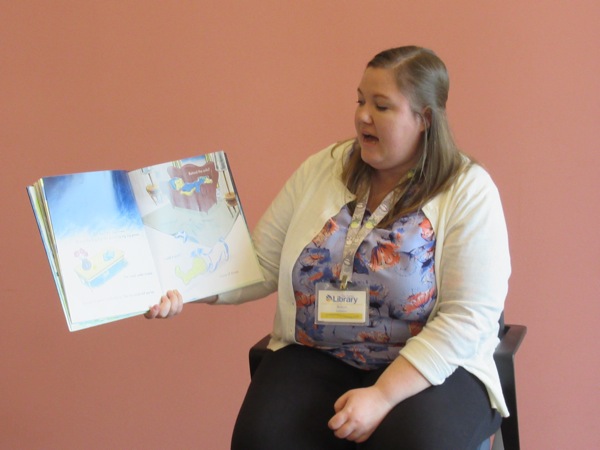 Neighbors | Jessica Harker.Librarian Amelia Dale read books about rain to children gathered at the Michael Kusalaba library's rainy day event.