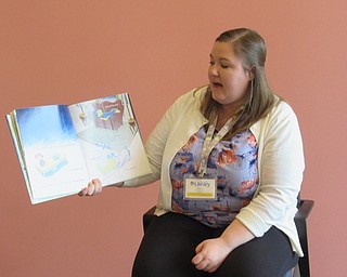 Neighbors | Jessica Harker.Librarian Amelia Dale read books about rain to children gathered at the Michael Kusalaba library's rainy day event.