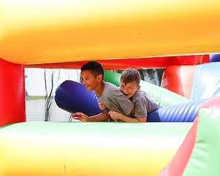Landon Masterson, 9 , left, and Jayden Sheridan, 9, both of Austintown, race each other on an inflatable obstacle course during the Autism Warrior Event at the Canfield Fairgrounds on Saturday. EMILY MATTHEWS | THE VINDICATOR