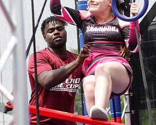 Reygan Long, 17, participates in a ninja obstacle course, with help from Travon Herst, with A&S Party Rental, during the Autism Warrior Event at the Canfield Fairgrounds on Saturday. She completed the course with her twin sister Kamryn, both of whom have autism and cheer with Miss Dana's Diamonds. EMILY MATTHEWS | THE VINDICATOR