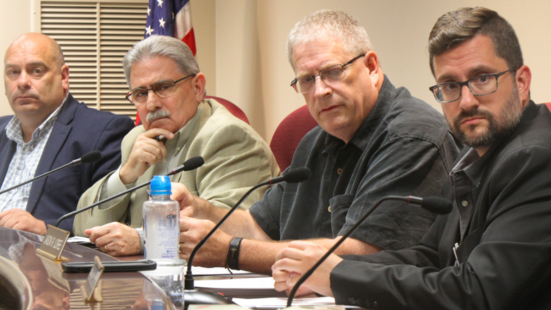 Boardman Township trustees Larry Moliterno, left, Tom Costello, Brad Calhoun and township Administrator Jason Loree listen to residents about flooding issues at the trustees meeting Monday night.