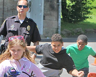 Youngstown Police Department Capt. Jason Simon leads children, from left Julissa Pike, 11; Nelson Figueroa, 12 and Xavier Weaver, 12, through an obstacle course at Homestead Park as part of the Penguin Challenge.


