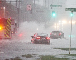 Motorists and a fire truck make their way in a downpour and through deep water along Market Street in Boardman Township on May 28 near the Southwoods medical complex. 