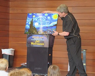 Neighbors | Jessica Harker .Magician Jeff Wawrzaszek used a copy of Vincent Van Gogh's Starry Night to create an optical illusion at the Michael Kusalaba library June 7.