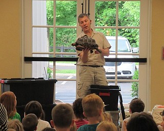 Neighbors | Jessica Harker .Outback Ray held the red-footed tortoise, named Franklin, showing off to the community members gathered to watch his Amazing Animal Show at the Poland library.