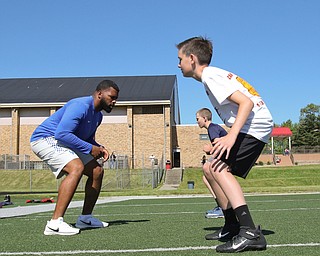  ROBERT K.YOSAY  | THE VINDICATOR..Cardinal Mooney annual Football Camp of Champions for kids 3-8 - about 125 football players attended the two day camp ..Caleb Hnat 12 from cortland  takes directions from  Courtney Love