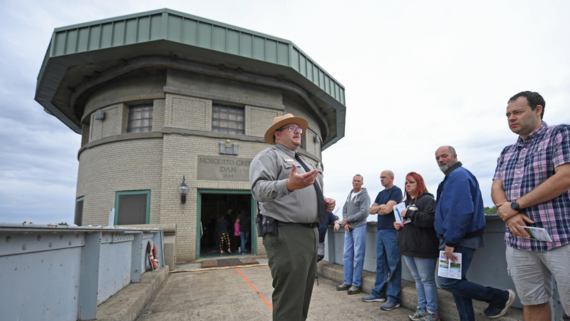 Park ranger Jamison Conley speaks to guests on the bridge leading to the control room of the Mosquito Creek Dam. The occasion was an observance Saturday of Mosquito Lake’s 75th anniversary. The dam  was built in a mere 90 days before being finished in April 1944. 