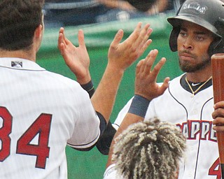 Michael Cooper, right, of the Mahoning Valley Scrappers, gets congratulations from teammates Ethan Hankins (34), and George Valera, after scoring in the first inning of game with the Batavia Muckdogs. The Scrappers won 3-1 in Monday's game at Eastwood Field in Niles.