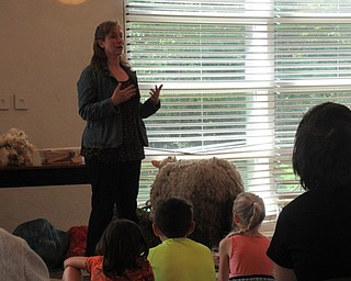 Neighbors | Jessica Harker .Winterberry Farm representative Lindsay Sprauge visited the Austintown library June 12, answering questions about sheep from the children gathered at the event.